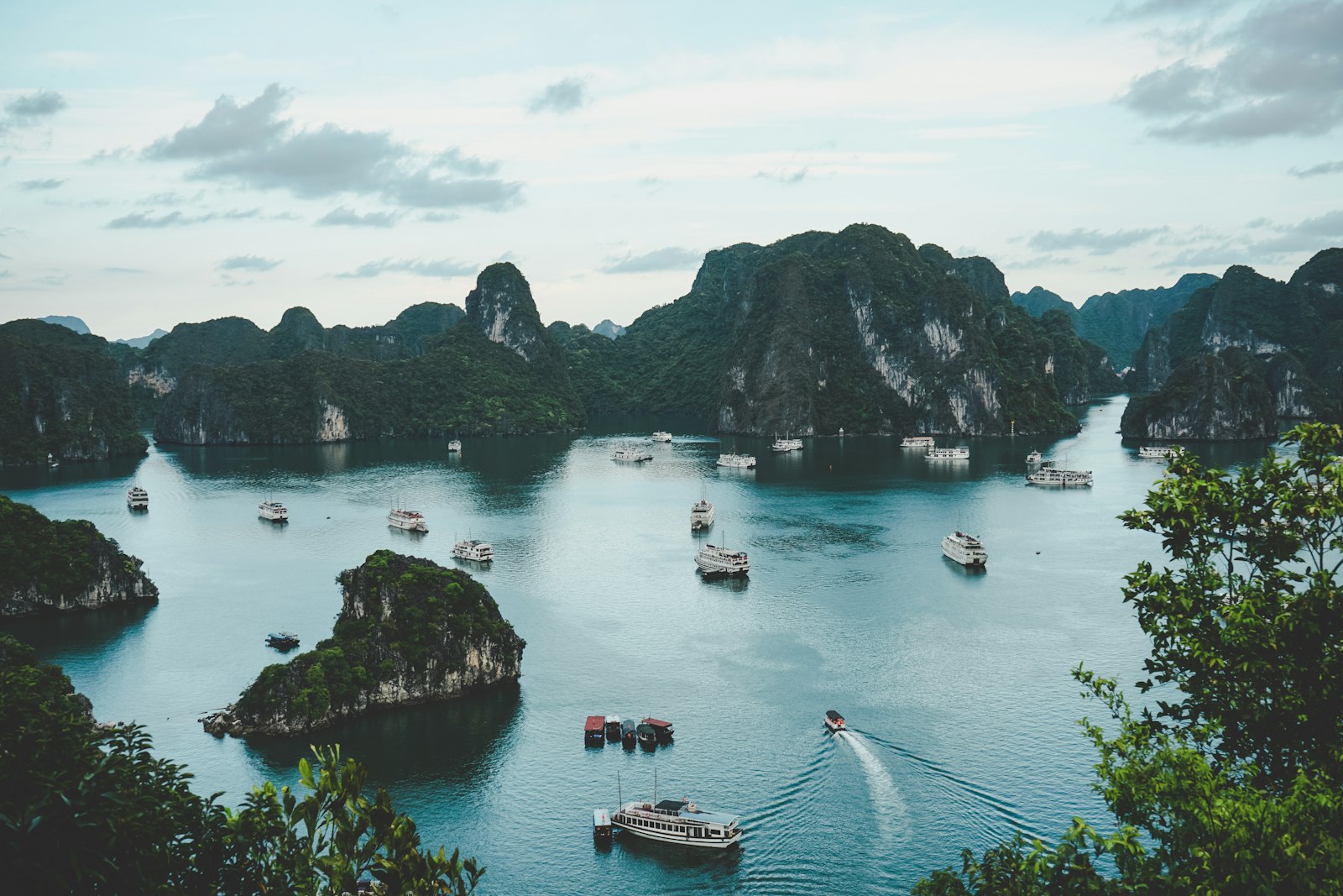 Boats among limestone islands in a green bay